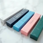 Assortiment de paquets de cigarettes Vogue en différentes couleurs disposés en éventail sur marbre blanc